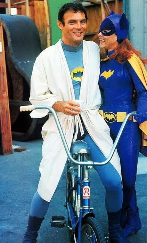 Adam West as Batman with on set transport bicycle next to Batgirl